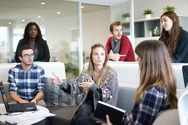 Equipo de trabajo conversando en una sala de juntas informal de una oficina